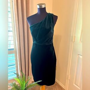 One shoulder deep green velvet dress.